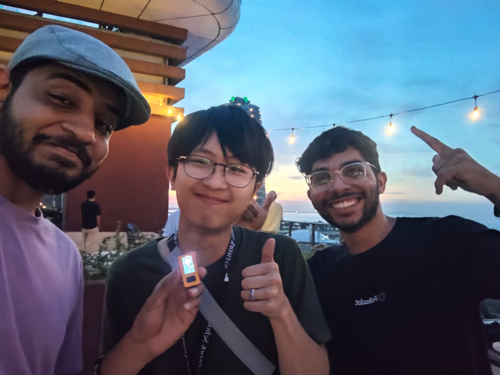 Team with Sidebrain pin at dusk on a rooftop terrace